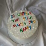 Silver glitter cake with colorful lettering saying do whatever the fuck makes you happy