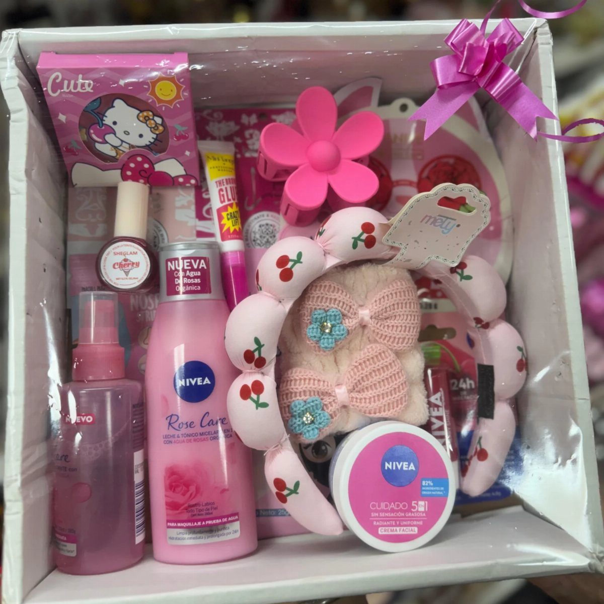 Pink beauty gift box containing skincare products, a cherry scrunchie, and cute accessories.